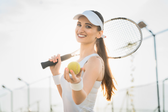 一个正在打网球的女人在展示球