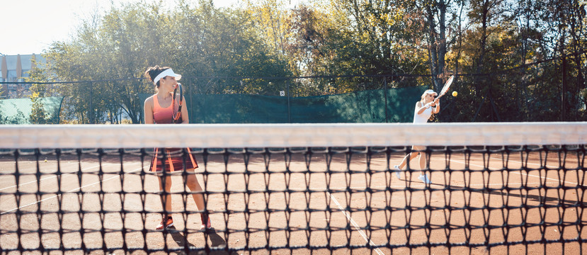 穿红色运动服的女子打网球击球
