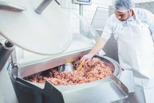 屠夫检查肉糜的质量和稠度是否合适