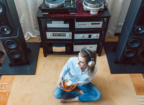 在家里用高保真音响听音乐的女人