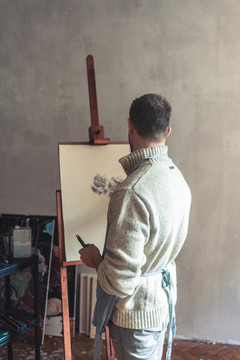 男性艺术家在画架板上素描的后视图