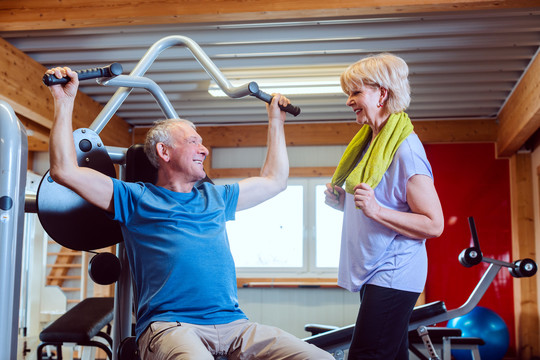 快乐的老人和他的妻子在健身房锻炼