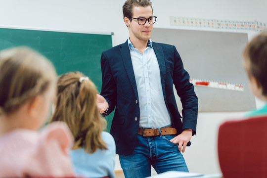 在学校课堂上，老师站在学生面前解释有趣的事情