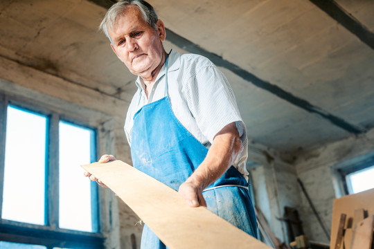 有经验的木匠检查木板是否平整，是否可以使用