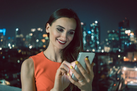 城市环境中使用手机社交媒体的女性微笑