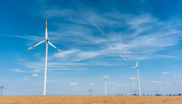 在蓝天下的农村地区，风力涡轮机在田间发电