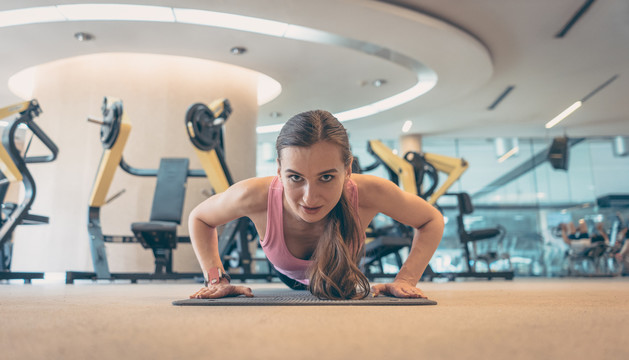 女子在运动健身房做俯卧撑以增强体质