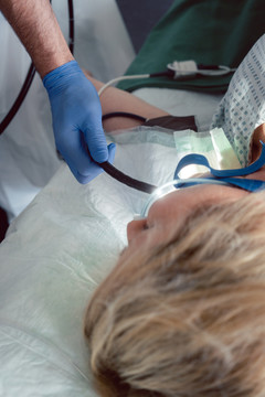 医生在胃镜检查时将内窥镜摄像头插入患者口腔