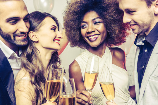 男女在庆祝生日或新年派对时，用起泡酒碰杯
