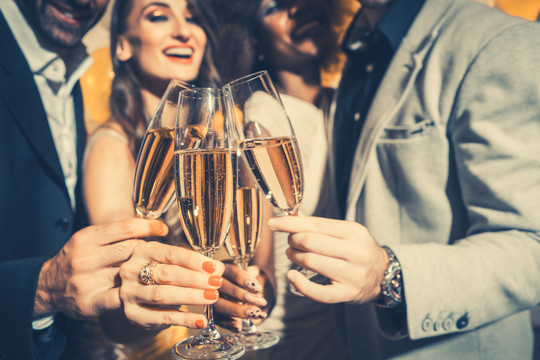 男女在庆祝生日或新年派对时，用起泡酒碰杯