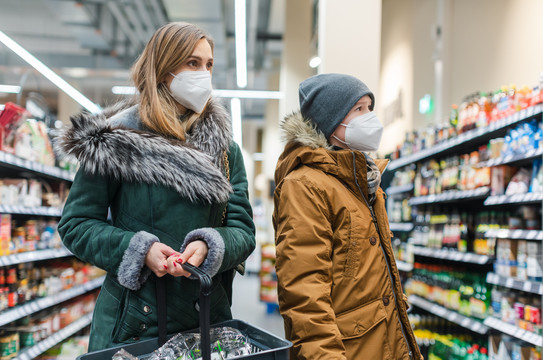 流感大流行期间，家人站在货架前在超市购物