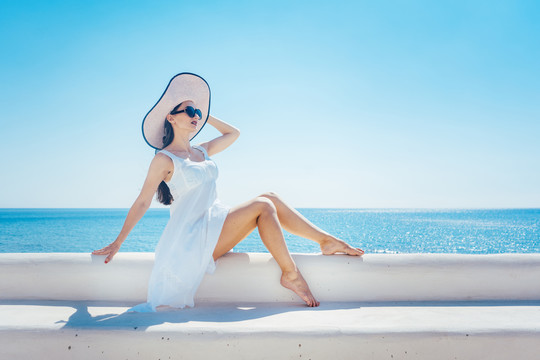 坐在希腊海滩上晒太阳看海的女人