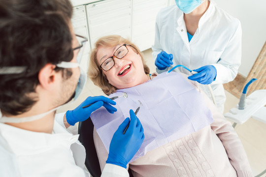 牙医团队在手术中与老年患者交谈，解释治疗方法
