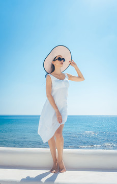 在希腊，一个以海洋为背景享受阳光的女人