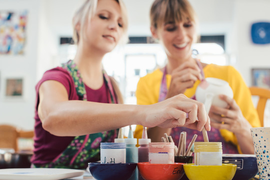 两个女朋友在一个业余工作室里画自己的手工陶瓷