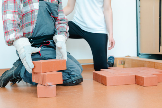 职业治疗工作者在现实生活培训中重新学习砌砖