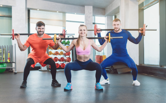 一群健康的年轻人在一个现代化的健身房里做举重运动