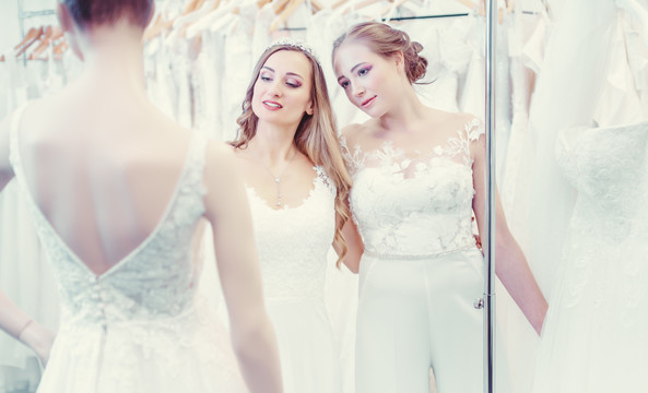 两个同性结婚的新娘看着服装模特选择穿什么