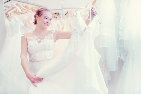 年轻女子在婚纱店购物，想买一件新娘穿的衣服