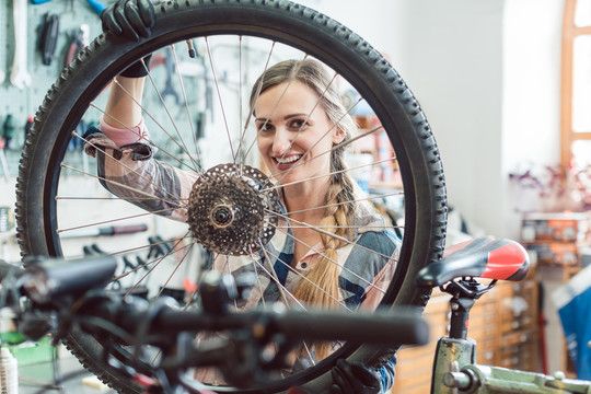 非常快乐的自行车修理工从自行车的轮子里看过去