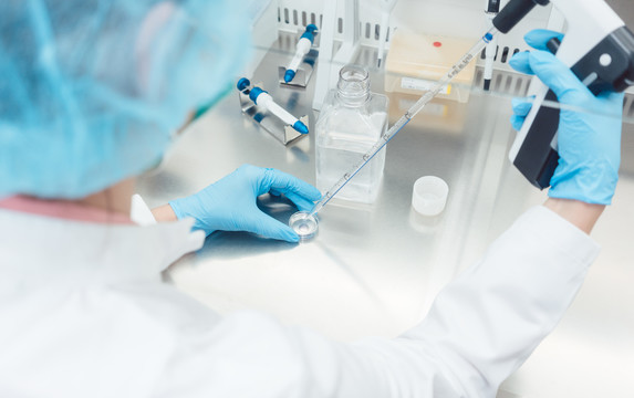 实验室科学家使用移液管和皮氏培养皿进行生物技术实验