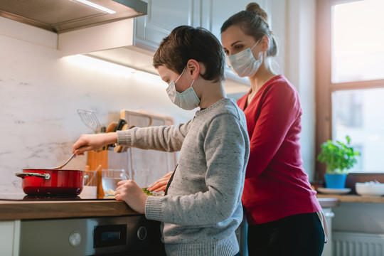 冠状病毒危机期间家庭在厨房做饭