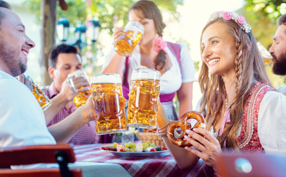 在巴伐利亚的酒吧里，一对夫妇拿着大量啤酒互相碰杯