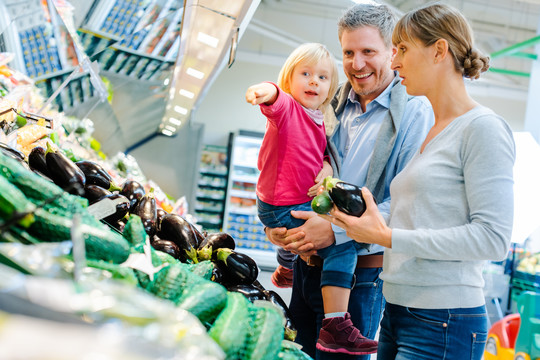 一个快乐的家庭，孩子在超市买农产品玩得很开心