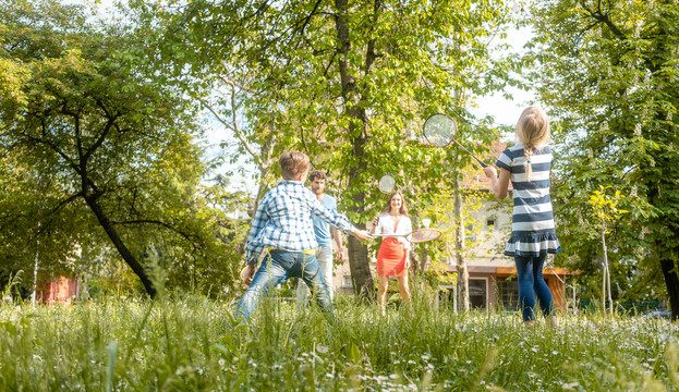 夏天，一家人在草地上打羽毛球，玩得很开心
