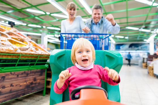 情侣们在超市购物时使用一种特殊的儿童手推车以获得更多乐趣