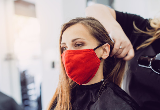 一位戴着红色面罩的女士在一家理发店做新发型