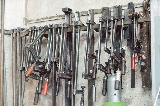 金属制品车间的杆夹和其他工具悬挂在墙上