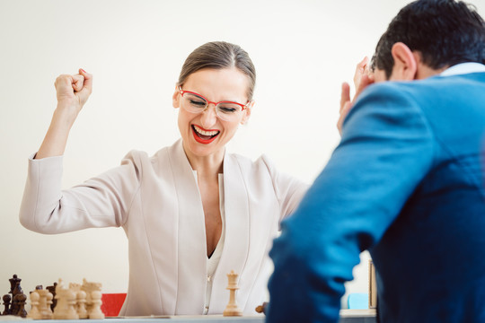 由于更好的策略，兴奋的女商人赢得了国际象棋比赛