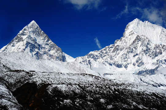 西藏蓝天下两座尖顶雪山