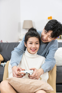 年轻情侣在家玩游戏