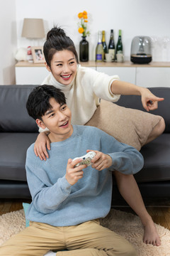 年轻情侣在家玩游戏