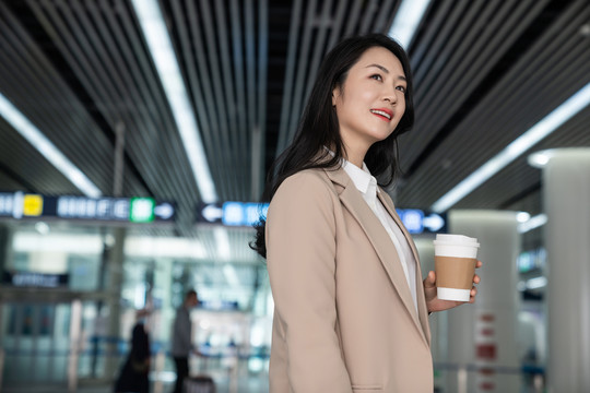 商务女士在机场拿一杯咖啡