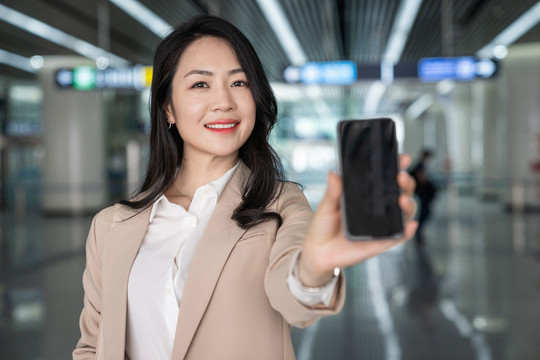 商务女士在机场展示手机