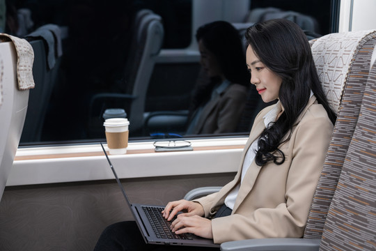商务女士乘坐地铁使用笔记本电脑