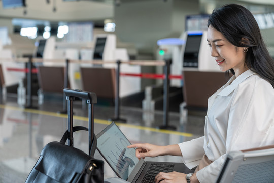 商务女士在机场使用笔记本电脑