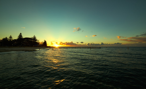 日落阳光照耀堤防海面摄影照