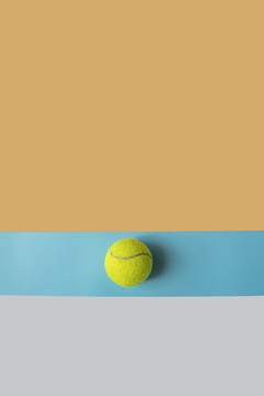拼接背景中放着一只网球