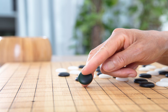 一枚黑色围棋棋子预要落下