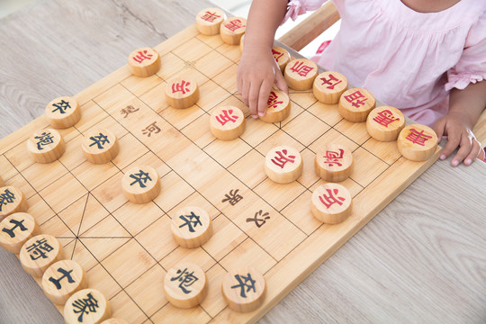 小女孩在和妈妈下中国象棋