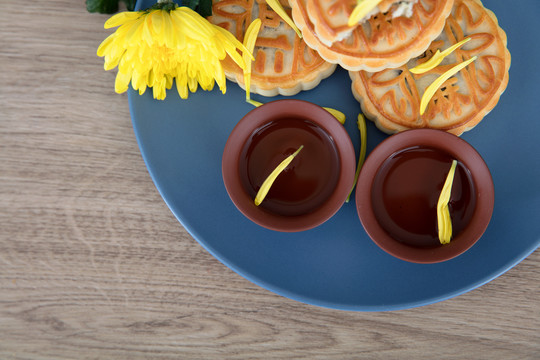 月饼和茶水及一朵菊花