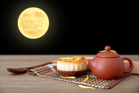 桌子上一壶茶和一块月饼