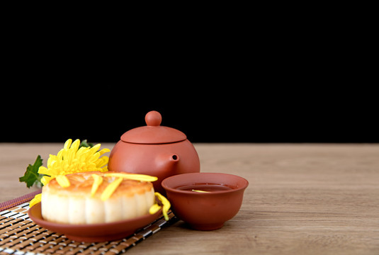 月饼和一壶茶及一朵金黄色的菊花