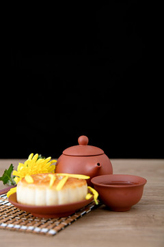 月饼和一壶茶及一朵金黄色的菊花