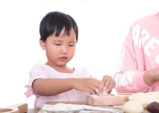 白背景前中国儿童在学习做月饼