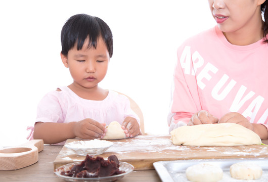 中国妈妈在教女儿学习包月饼